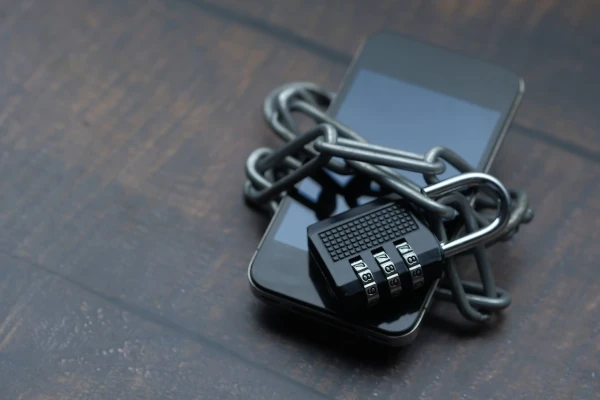 An iPhone wrapped in a chain and padlocked. The image represents digital security.