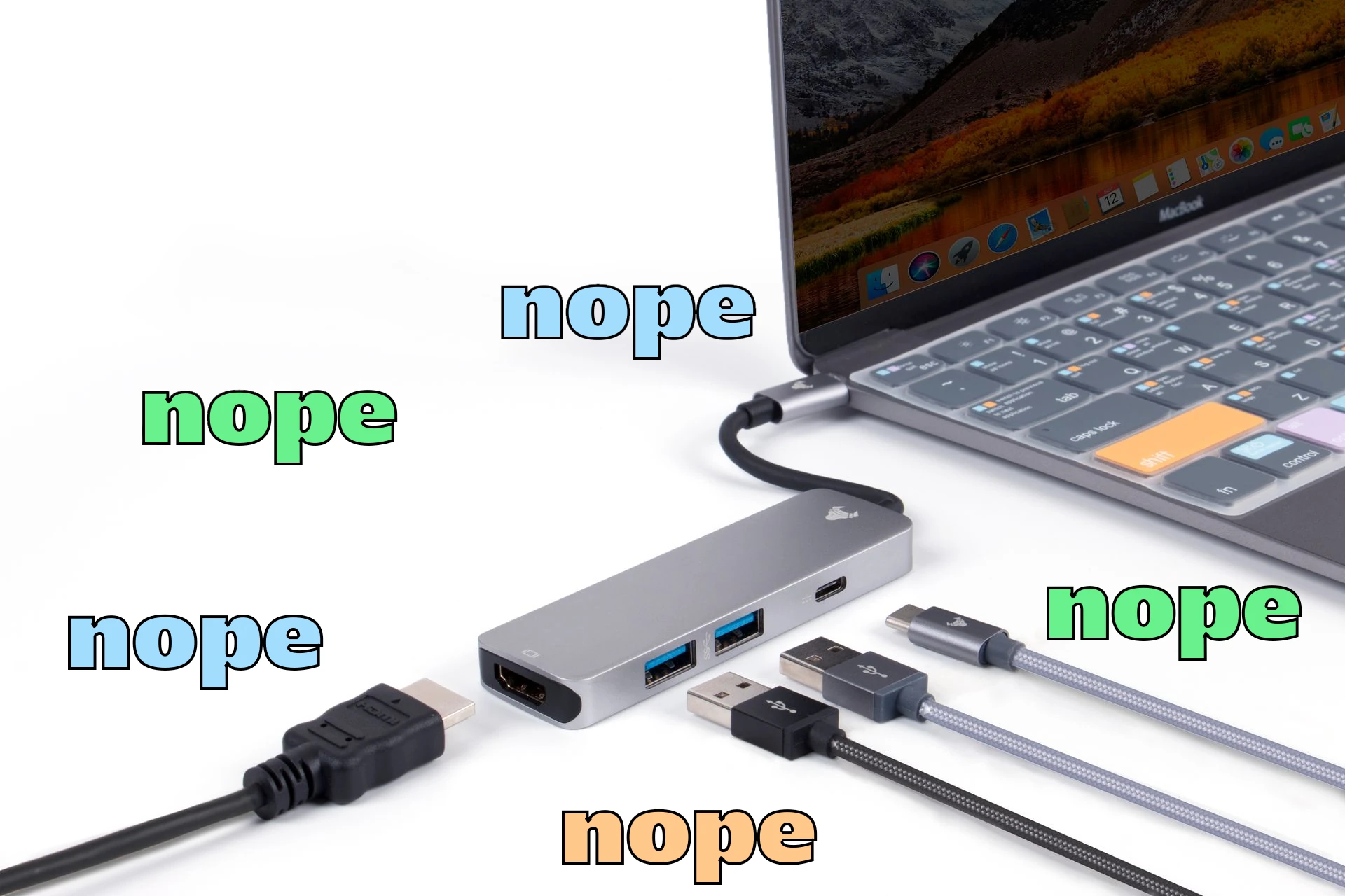 A laptop and USB hub with multiple different cables being plugged in, and the word 'nope' written near every one of the cables and adapter.