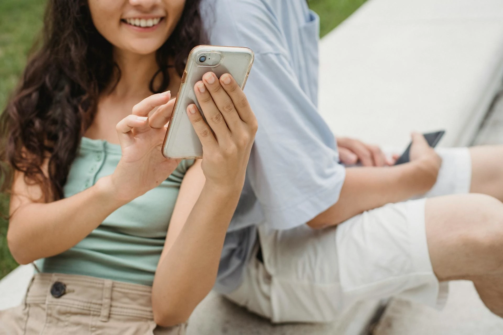 Two people looking at what's on one of their phones.